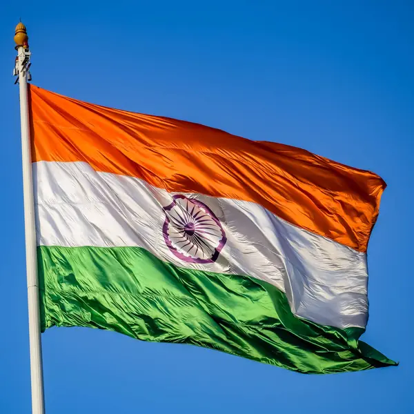 stock image India flag flying high at Connaught Place with pride in blue sky, India flag fluttering, Indian Flag on Independence Day and Republic Day of India, tilt up shot, Waving Indian flag, Har Ghar Tiranga