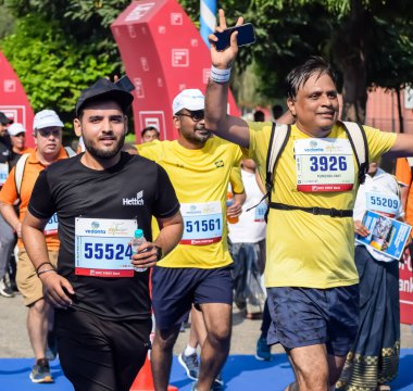 Yeni Delhi, Hindistan - 15 Ekim 2023 - Bitmek üzere olan maraton katılımcılarının bitiş çizgisini geçmek üzere olan Delhi Yarı Maratonu 2023