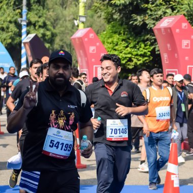 Yeni Delhi, Hindistan - 15 Ekim 2023 - Bitmek üzere olan maraton katılımcılarının bitiş çizgisini geçmek üzere olan Delhi Yarı Maratonu 2023