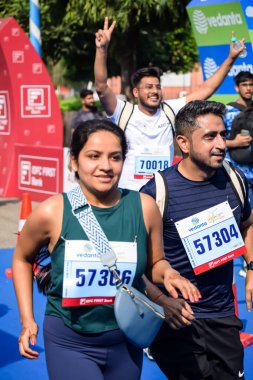 Yeni Delhi, Hindistan - 15 Ekim 2023 - Bitmek üzere olan maraton katılımcılarının bitiş çizgisini geçmek üzere olan Delhi Yarı Maratonu 2023