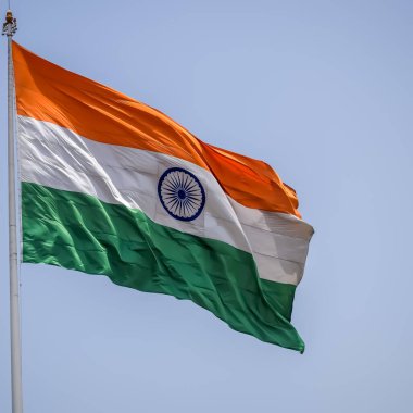 India flag flying high at Connaught Place with pride in blue sky, India flag fluttering, Indian Flag on Independence Day and Republic Day of India, tilt up shot, Waving Indian flag, Har Ghar Tiranga