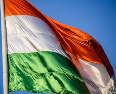 India flag flying high at Connaught Place with pride in blue sky, India flag fluttering, Indian Flag on Independence Day and Republic Day of India, tilt up shot, Waving Indian flag, Har Ghar Tiranga