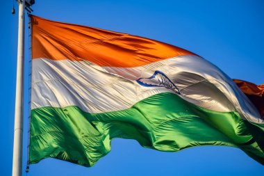 India flag flying high at Connaught Place with pride in blue sky, India flag fluttering, Indian Flag on Independence Day and Republic Day of India, tilt up shot, Waving Indian flag, Har Ghar Tiranga