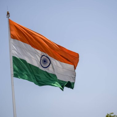 India flag flying high at Connaught Place with pride in blue sky, India flag fluttering, Indian Flag on Independence Day and Republic Day of India, tilt up shot, Waving Indian flag, Har Ghar Tiranga