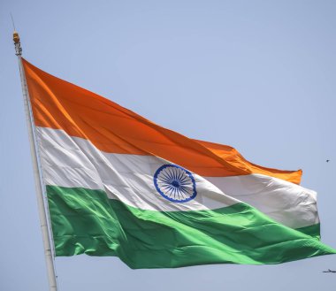 India flag flying high at Connaught Place with pride in blue sky, India flag fluttering, Indian Flag on Independence Day and Republic Day of India, tilt up shot, Waving Indian flag, Har Ghar Tiranga