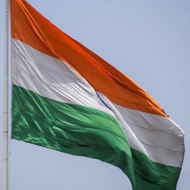 India flag flying high at Connaught Place with pride in blue sky, India flag fluttering, Indian Flag on Independence Day and Republic Day of India, tilt up shot, Waving Indian flag, Har Ghar Tiranga