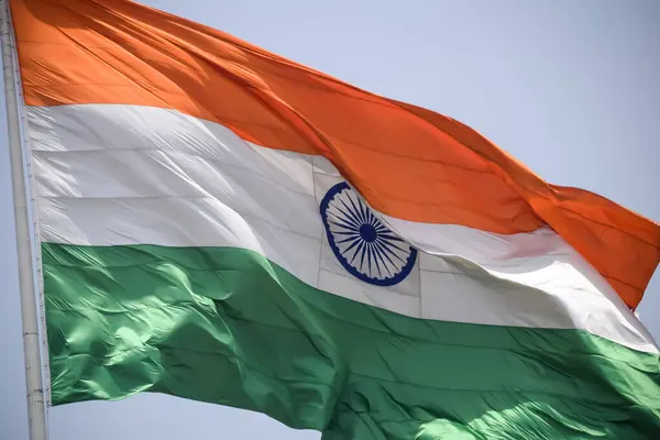 stock image India flag flying high at Connaught Place with pride in blue sky, India flag fluttering, Indian Flag on Independence Day and Republic Day of India, tilt up shot, Waving Indian flag, Har Ghar Tiranga