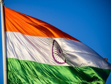 India flag flying high at Connaught Place with pride in blue sky, India flag fluttering, Indian Flag on Independence Day and Republic Day of India, tilt up shot, Waving Indian flag, Har Ghar Tiranga