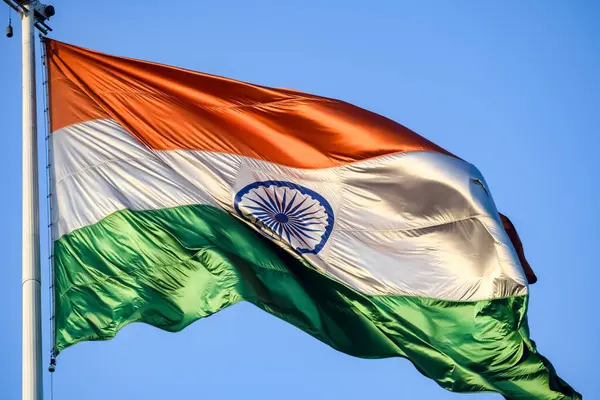 India flag flying high at Connaught Place with pride in blue sky, India flag fluttering, Indian Flag on Independence Day and Republic Day of India, tilt up shot, Waving Indian flag, Har Ghar Tiranga