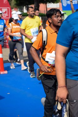 Yeni Delhi, Hindistan - 15 Ekim 2023 - Bitmek üzere olan maraton katılımcılarının bitiş çizgisini geçmek üzere olan Delhi Yarı Maratonu 2023