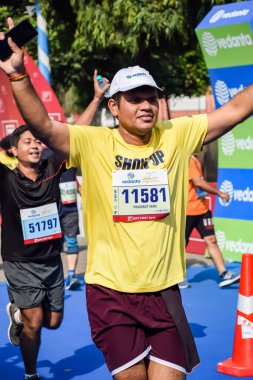 Yeni Delhi, Hindistan - 15 Ekim 2023 - Bitmek üzere olan maraton katılımcılarının bitiş çizgisini geçmek üzere olan Delhi Yarı Maratonu 2023
