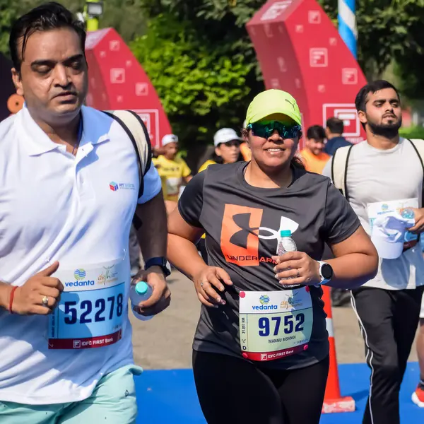 Yeni Delhi, Hindistan - 15 Ekim 2023 - Bitmek üzere olan maraton katılımcılarının bitiş çizgisini geçmek üzere olan Delhi Yarı Maratonu 2023