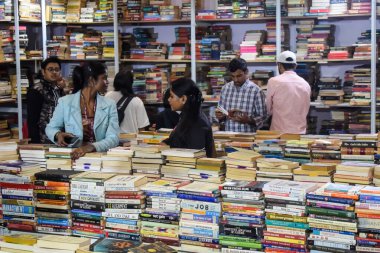 Delhi, Hindistan, 17 Şubat 2024 - Çeşitli yaş gruplarından insanlar Delhi Uluslararası Kitap Fuarı 'ndaki bir kitapçıda çeşitli kitaplar okuyor, Bharat Mandapam kompleksindeki Yıllık Kitap Fuarı' nda kitaplar