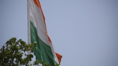 India flag flying high at Connaught Place with pride in blue sky, India flag fluttering, Indian Flag on Independence Day and Republic Day of India, tilt up shot, Waving Indian flag, Har Ghar Tiranga