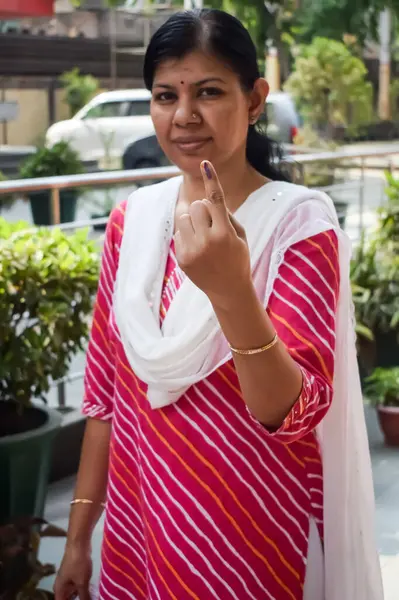 Yeni Delhi, Hindistan - 25 Mayıs 2024 - Doğu Delhi bölgesindeki genel Lok Sabha Seçimleri için oy kullandıktan sonra dövmeli parmaklarını gösteren kimliği belirsiz kişiler