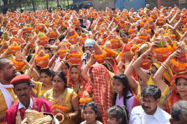 New Delhi, India July 25 2024 - Women with Kalash on head during Jagannath Temple Mangal Kalash Yatra, Indian Hindu devotees carry earthen pots containing sacred water with a coconut on top clipart