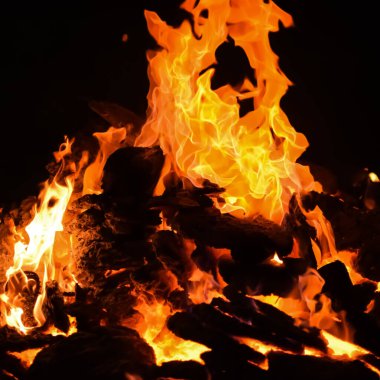 Siyah arka planda alevler, alev alev dokusu arka planda, çok güzel, ateş yanıyor, ateş odun ve inek gübresi ateşiyle yanıyor.