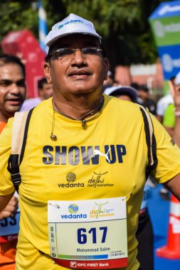 Yeni Delhi, Hindistan - 15 Ekim 2023 - Bitmek üzere olan maraton katılımcılarının bitiş çizgisini geçmek üzere olan Delhi Yarı Maratonu 2023