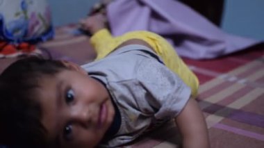 10 aylık sevimli küçük Hintli çocuk evde mutlu anların tadını çıkarıyor, tatlı küçük çocuk evde oynayan ve gülümseyen küçük bebekle eğleniyor.