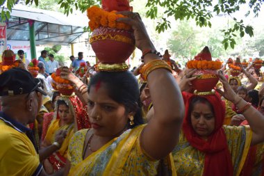 Yeni Delhi, Hindistan 25 Temmuz 2024 - Jagannath Tapınağı sırasında Kalaşlı kadınlar Mangal Kalash Yatra, Hintli Hintli dindarlar üzerinde hindistancevizi olan toprak kapları taşıyorlar