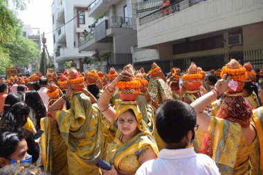 Yeni Delhi, Hindistan 25 Temmuz 2024 - Jagannath Tapınağı sırasında Kalaşlı kadınlar Mangal Kalash Yatra, Hintli Hintli dindarlar üzerinde hindistancevizi olan toprak kapları taşıyorlar