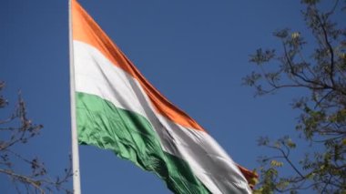 India flag flying high at Connaught Place with pride in blue sky, India flag fluttering, Indian Flag on Independence Day and Republic Day of India, tilt up shot, Waving Indian flag, Har Ghar Tiranga
