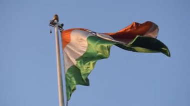 India flag flying high at Connaught Place with pride in blue sky, India flag fluttering, Indian Flag on Independence Day and Republic Day of India, tilt up shot, Waving Indian flag, Har Ghar Tiranga