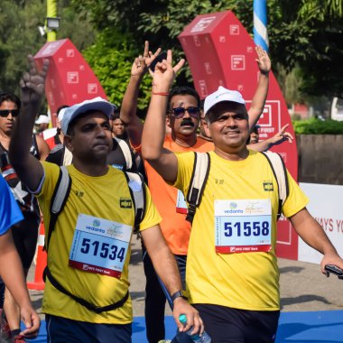 Yeni Delhi, Hindistan - 15 Ekim 2023 - Bitmek üzere olan maraton katılımcılarının bitiş çizgisini geçmek üzere olan Delhi Yarı Maratonu 2023