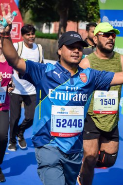 Yeni Delhi, Hindistan - 15 Ekim 2023 - Bitmek üzere olan maraton katılımcılarının bitiş çizgisini geçmek üzere olan Delhi Yarı Maratonu 2023