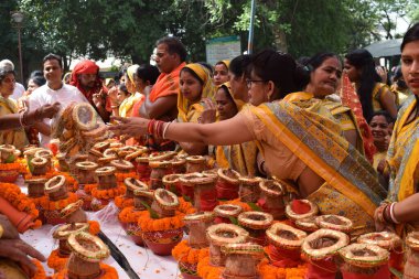 New Delhi, India July 25 2024 - Women with Kalash on head during Jagannath Temple Mangal Kalash Yatra, Indian Hindu devotees carry earthen pots containing sacred water with a coconut on top clipart