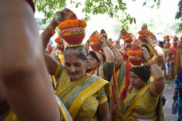 stock image New Delhi, India July 25 2024 - Women with Kalash on head during Jagannath Temple Mangal Kalash Yatra, Indian Hindu devotees carry earthen pots containing sacred water with a coconut on top