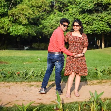 Hintli çift doğum çekimi için poz veriyor. Delhi 'deki Lodhi Garden' da yeni doğan bebeğe kucak açıyorlar. Anne ve babalar çocuklarını karşıladıkları için annelik fotoğrafı çekiyorlar.