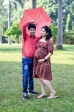 Hintli çift doğum çekimi için poz veriyor. Delhi 'deki Lodhi Garden' da yeni doğan bebeğe kucak açıyorlar. Anne ve babalar çocuklarını karşıladıkları için annelik fotoğrafı çekiyorlar.