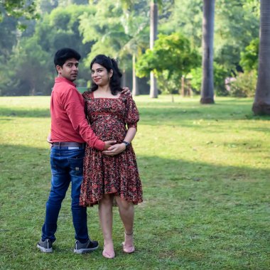 Hintli çift doğum çekimi için poz veriyor. Delhi 'deki Lodhi Garden' da yeni doğan bebeğe kucak açıyorlar. Anne ve babalar çocuklarını karşıladıkları için annelik fotoğrafı çekiyorlar.