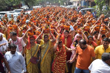 Yeni Delhi, Hindistan 25 Temmuz 2024 - Jagannath Tapınağı sırasında Kalaşlı kadınlar Mangal Kalash Yatra, Hintli Hintli dindarlar üzerinde hindistancevizi olan toprak kapları taşıyorlar