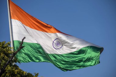 India flag flying high at Connaught Place with pride in blue sky, India flag fluttering, Indian Flag on Independence Day and Republic Day of India, tilt up shot, Waving Indian flag, Har Ghar Tiranga