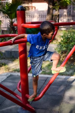 Asyalı çocuk sabah vakti sosyete parkında rutin egzersiz yapıyor. Kendini hayat boyu zinde tutmak için şirin bir çocuk egzersizi ve spor salonu. Açık havada çocuk egzersizi.
