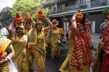 Yeni Delhi, Hindistan 25 Temmuz 2024 - Jagannath Tapınağı sırasında Kalaşlı kadınlar Mangal Kalash Yatra, Hintli Hintli dindarlar üzerinde hindistancevizi olan toprak kapları taşıyorlar