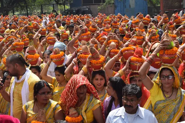 Yeni Delhi, Hindistan 25 Temmuz 2024 - Jagannath Tapınağı sırasında Kalaşlı kadınlar Mangal Kalash Yatra, Hintli Hintli dindarlar üzerinde hindistancevizi olan toprak kapları taşıyorlar