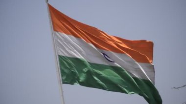 India flag flying high at Connaught Place with pride in blue sky, India flag fluttering, Indian Flag on Independence Day and Republic Day of India, tilt up shot, Waving Indian flag, Har Ghar Tiranga