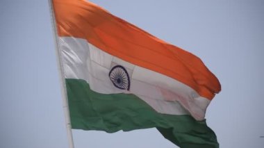 India flag flying high at Connaught Place with pride in blue sky, India flag fluttering, Indian Flag on Independence Day and Republic Day of India, tilt up shot, Waving Indian flag, Har Ghar Tiranga