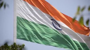 India flag flying high at Connaught Place with pride in blue sky, India flag fluttering, Indian Flag on Independence Day and Republic Day of India, tilt up shot, Waving Indian flag, Har Ghar Tiranga