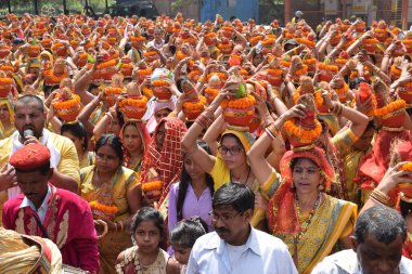 Yeni Delhi, Hindistan 25 Temmuz 2024 - Jagannath Tapınağı sırasında Kalaşlı kadınlar Mangal Kalash Yatra, Hintli Hintli dindarlar üzerinde hindistancevizi olan toprak kapları taşıyorlar