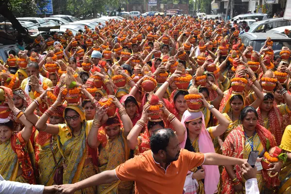 stock image New Delhi, India July 25 2024 - Women with Kalash on head during Jagannath Temple Mangal Kalash Yatra, Indian Hindu devotees carry earthen pots containing sacred water with a coconut on top