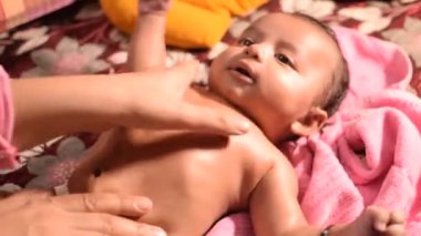 10 aylık anne, evde yağ masajı yapan sevimli küçük Hintli çocuk, yağ masajının tadını çıkaran küçük sevimli çocuk, küçük bebek anne tarafından sağlıklı bir masajın keyfini çıkarıyor.