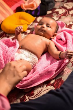 10 aylık sevimli Hintli çocuk evde annesine yağ masajı yapıyor, küçük tatlı çocuk yağ masajının tadını çıkarıyor, küçük çocuk annesinin sağlıklı masajının keyfini çıkarıyor.