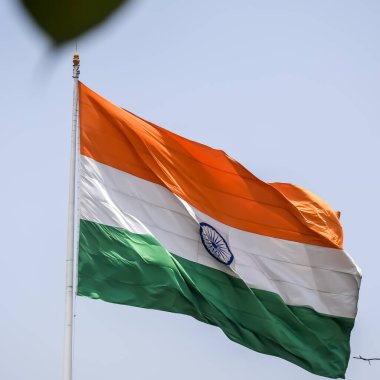 India flag flying high at Connaught Place with pride in blue sky, India flag fluttering, Indian Flag on Independence Day and Republic Day of India, tilt up shot, Waving Indian flag, Har Ghar Tiranga