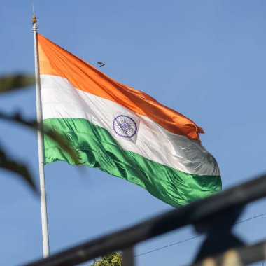 India flag flying high at Connaught Place with pride in blue sky, India flag fluttering, Indian Flag on Independence Day and Republic Day of India, tilt up shot, Waving Indian flag, Har Ghar Tiranga