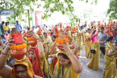 Yeni Delhi, Hindistan 25 Temmuz 2024 - Jagannath Tapınağı sırasında Kalaşlı kadınlar Mangal Kalash Yatra, Hintli Hintli dindarlar üzerinde hindistancevizi olan toprak kapları taşıyorlar
