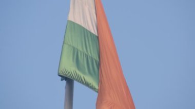 India flag flying high at Connaught Place with pride in blue sky, India flag fluttering, Indian Flag on Independence Day and Republic Day of India, tilt up shot, Waving Indian flag, Har Ghar Tiranga